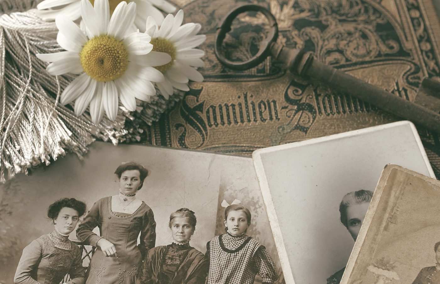 Gamla familjefotografier, en nyckel och en pressad prästkrage på ett bord.